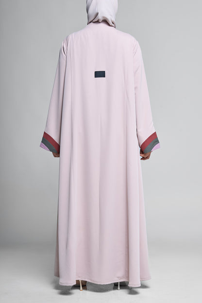عباية مفتوحة باللون الوردي الناعم مع طية صدر مموجة وأساور أكمام ثلاثية الألوان