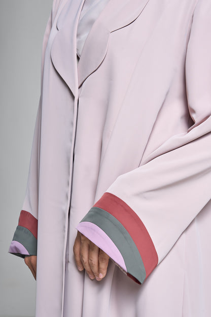عباية مفتوحة باللون الوردي الناعم مع طية صدر مموجة وأساور أكمام ثلاثية الألوان